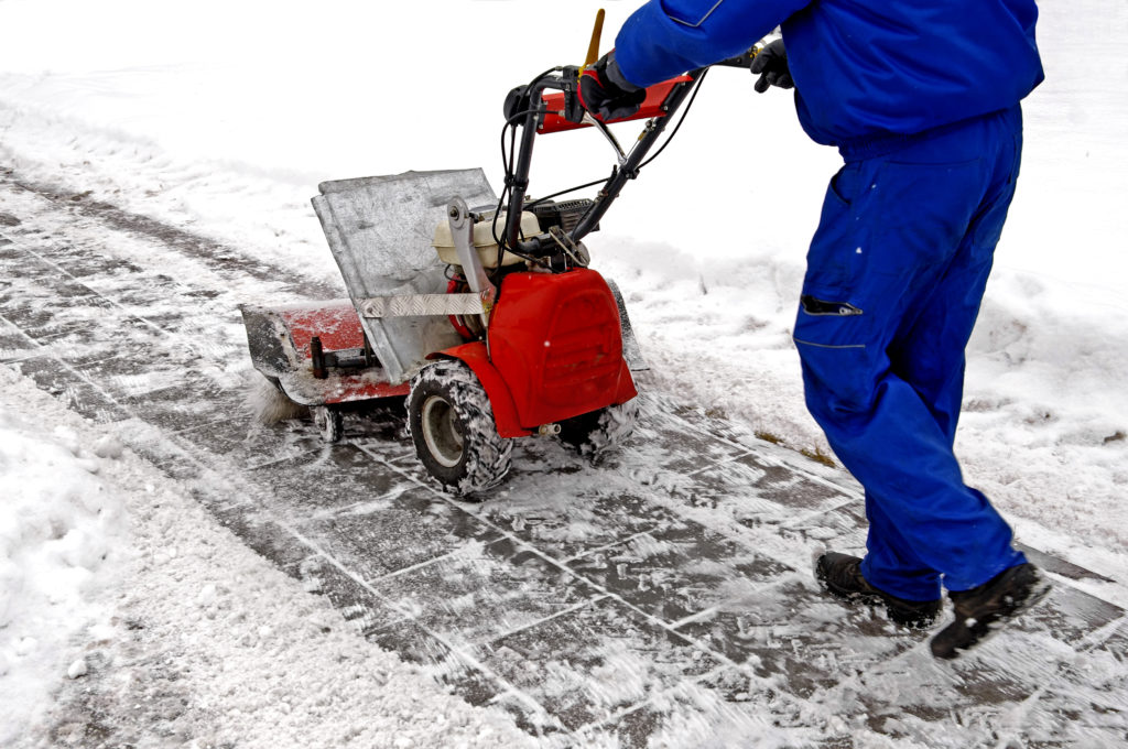 Man working with a snow blowing machine v