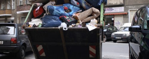 Berlin, Germany - February 19, 2007: An overflowing garbage dumpster in a street of Berlin-Neukoelln. Neukoelln is very densely populated and characterized by a high percentage of immigrants and welfare recipients